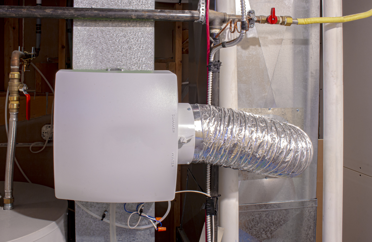 A home humidifier attached to the return duct with a bypass connection to the supply hot air duct.