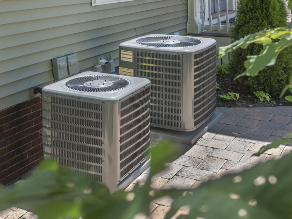 Two residential HVAC systems sitting outside of a Baltimore home.