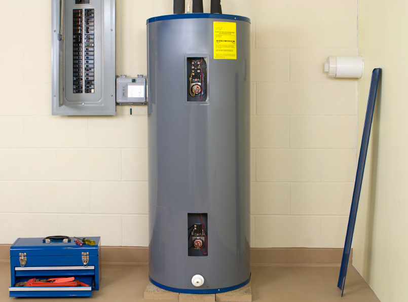 Electric water heater in the basement of a Maryland home with a tool box setting on the floor next to it.