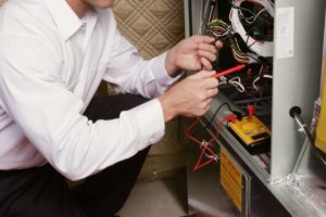 HVAC technician working on a home's furnace.