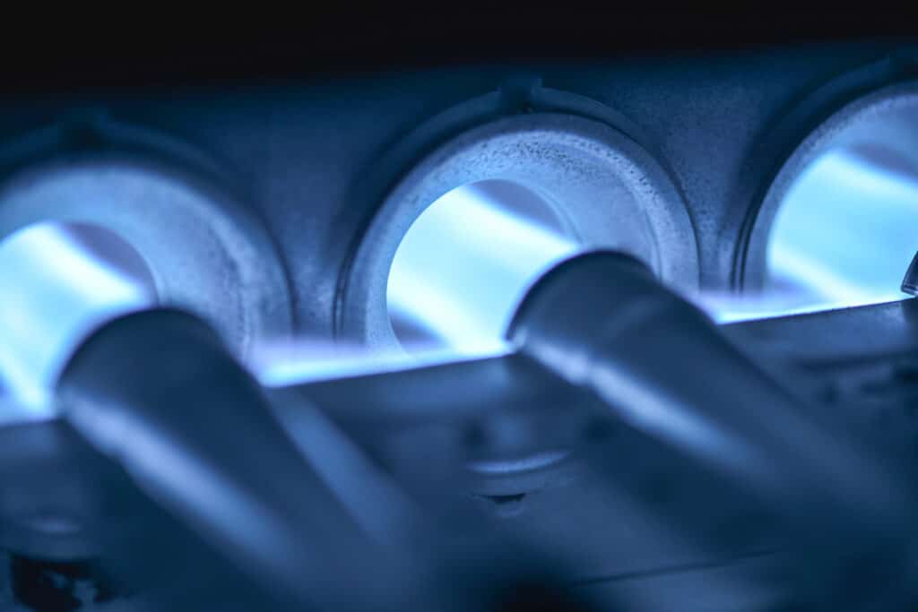 Close-up of blue pilot lights burning on a home furnace
