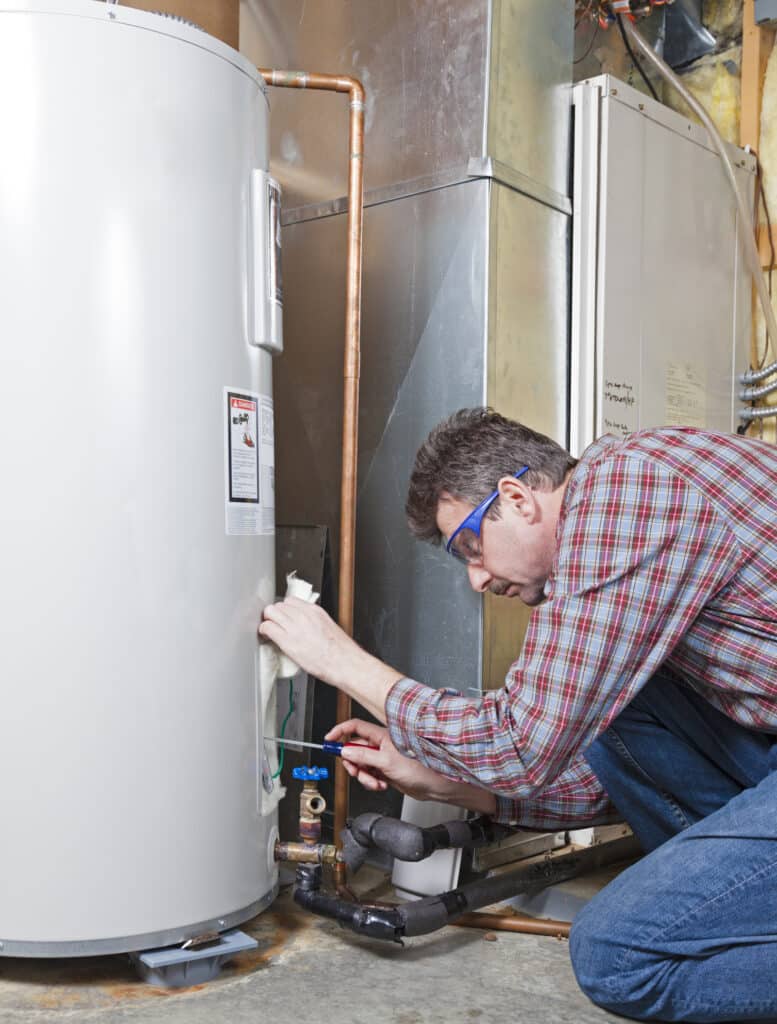A plumber performing maintenance on a residential tank water heater.