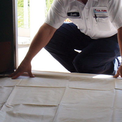 F.H. Furr technician laying out a sheet to ensure the homeowner's home stays clean