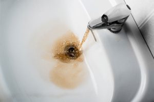 bathroom-faucet-with-brown-running-water
