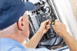 Electrician servicing a residential electrical panel.