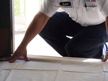 Technician laying down dropcloth to protect a home's flooring.