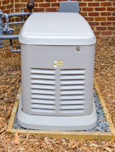 White standby generator next to a brick home.