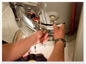 Focused view on plumber's hands as he repairs a water heater.