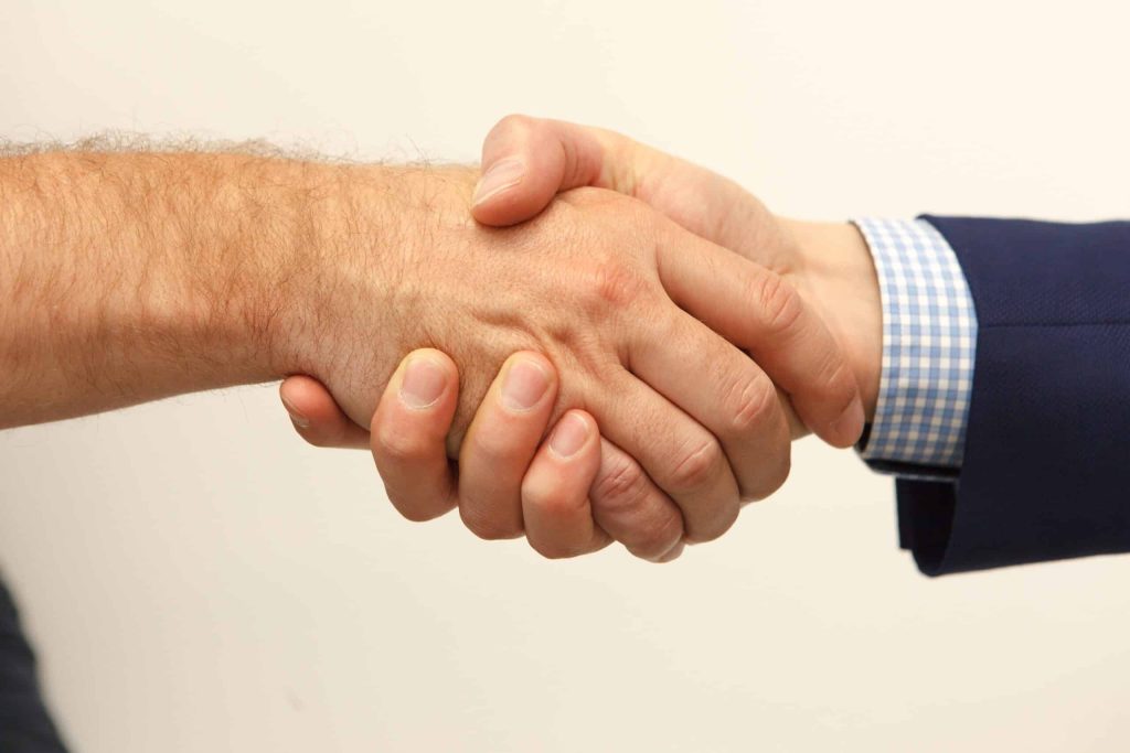 Two hands in a shake; making an agreement.