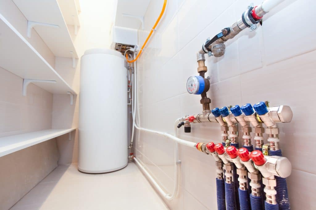 Copper valves, stainless ball valves and plastic pipes on a boiler room equipment in apartment during under renovation, remodeling and construction.